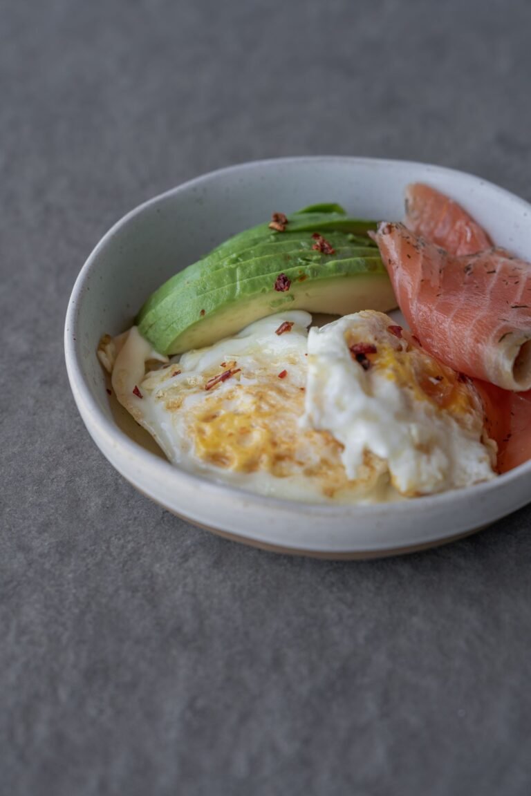 Plato con huevos, aguacate y salmón como ejemplo de una comida rica en proteína