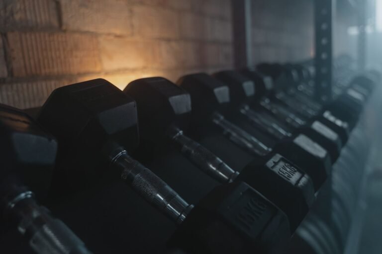 Mancuernas en un gimnasio con iluminación tenue durante la tarde-noche